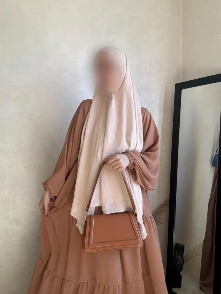 a person wearing a brown dress and a beige scarf